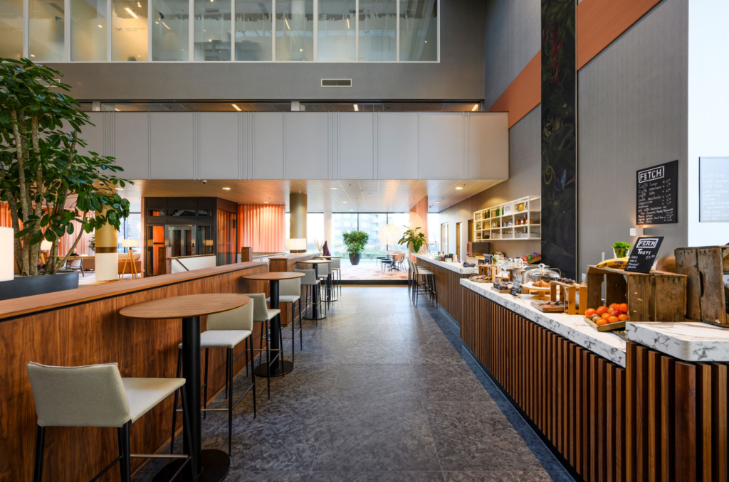 Moderne en sfeervol ingerichte koffiebar met zitgelegenheid in een open kantoorruimte aan de P.J. Oudweg.